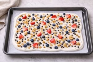 Frozen Yogurt Bark – My Favorite Healthy Freezer Treat 9 add fruit granola and chocolate chips on yogurt.jpg