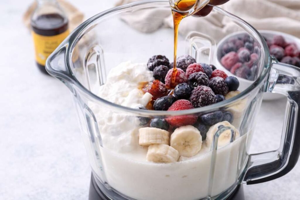 Best Vanilla Berry Smoothie Bowl Recipe for a Thick, Spoon able Texture 4 Adding almond milk, yogurt, and berries to blender