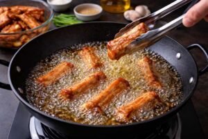 Chinese Fried Pork Spare Ribs Recipe – Crispy Garlic Pepper Ribs Better Than Takeout 7 Adding marinated pork spare ribs to hot oil