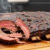Juicy smoked dino ribs with bark and smoke ring, close up