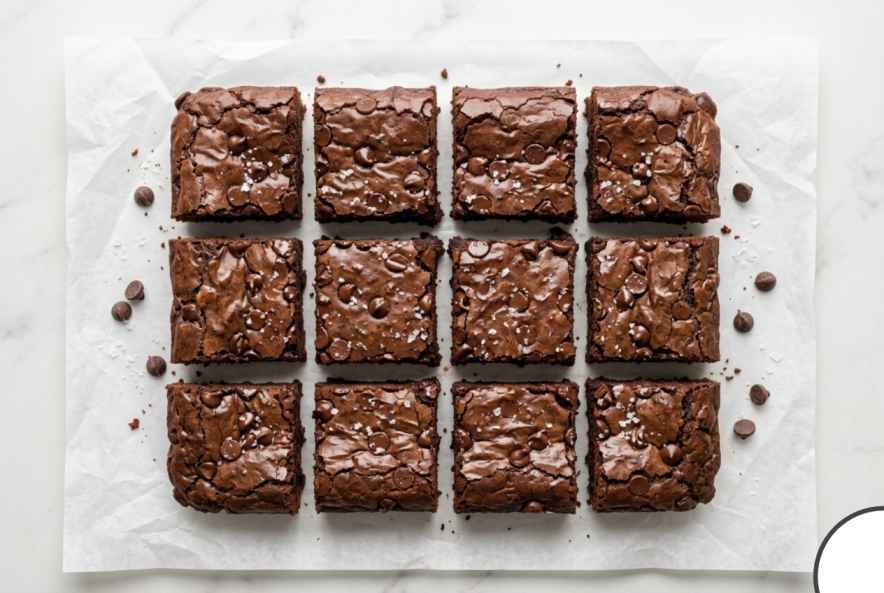 Sweet Potato Brownies (Fudgy, Flourless & Better Than You'd Expect) 17 Overhead view of sweet potato brownies cut into neat squares on parchment paper showing fudgy texture and melted chocolate chips