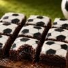 Little Debbie soccer-themed brownies recipe with fudgy chocolate interior, white vanilla icing, and black soccer ball decoration on a rustic wooden board