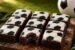 Little Debbie soccer-themed brownies recipe with fudgy chocolate interior, white vanilla icing, and black soccer ball decoration on a rustic wooden board